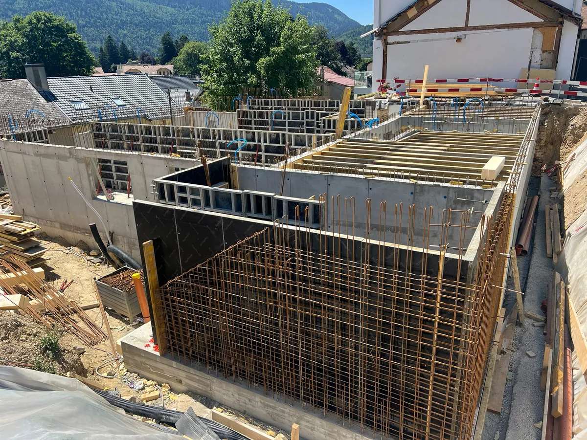 Vue d’ensemble d’un chantier XETI avec murs en béton, armatures et coffrages de plancher