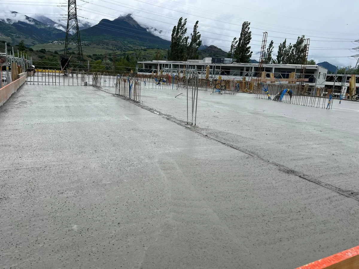Dalle bétonnée avec armatures en attente devant les montagnes