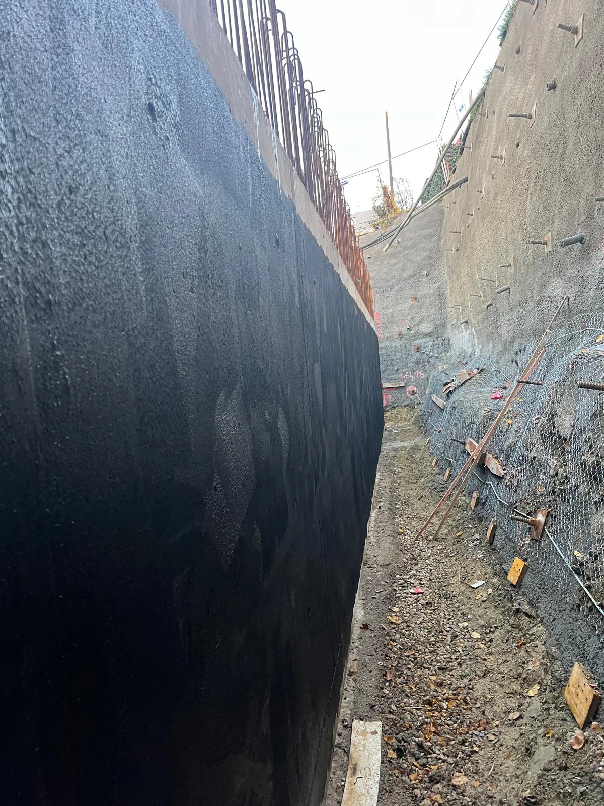 Enduit noir sur la face extérieure d’un mur de soubassement